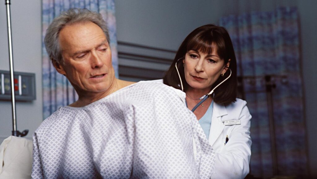 Clint Eastwood siendo auscultado por doctora