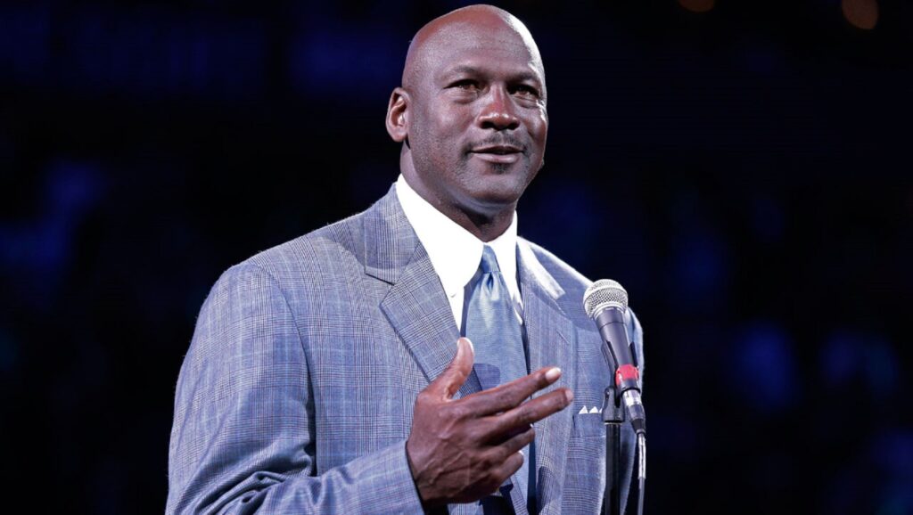 Michael Jordan con traje frente a un micrófono