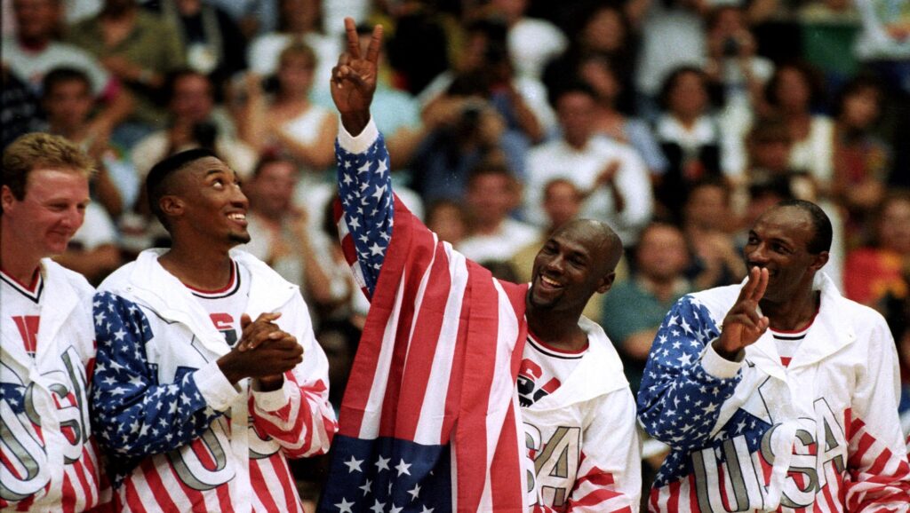 Larry Bird, Scottie Pippen, Michael Jordan y Clyde Drexler, en los Juegos Olímpicos de 1992, con la bandera de Estados Unidos