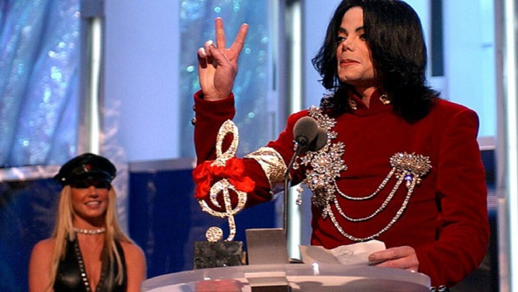 Michael Jackson hablando a micrófono con Britney Spears detrás