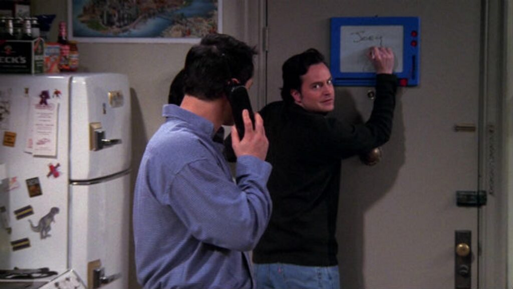 Escena de "Friends" con la pizarra del piso de "Joey" y "Chandler"