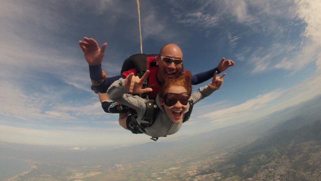 Mujer y hombre saltando en paracaídas