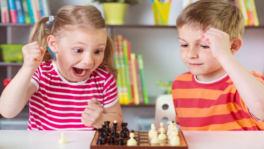 Niña y niño jugando al ajedrez
