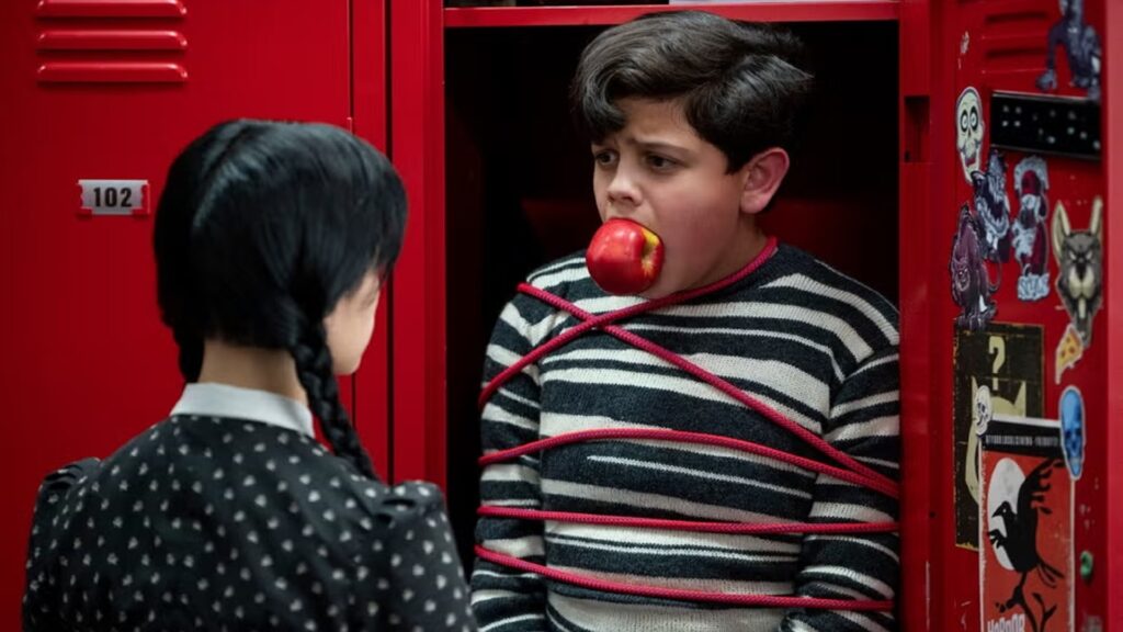 Escena de la serie Miércoles, encarrando a niño en el armario